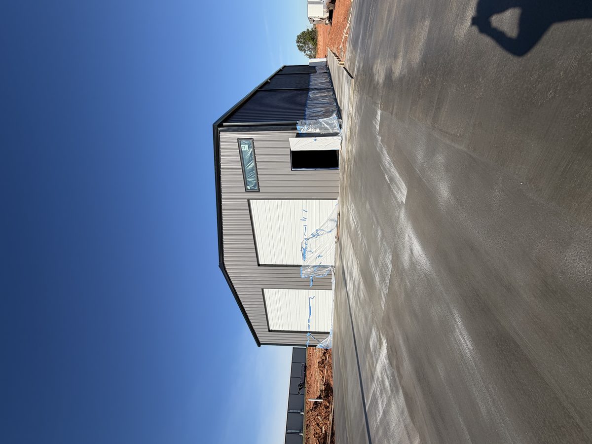 Gray metal building fresh concrete pad